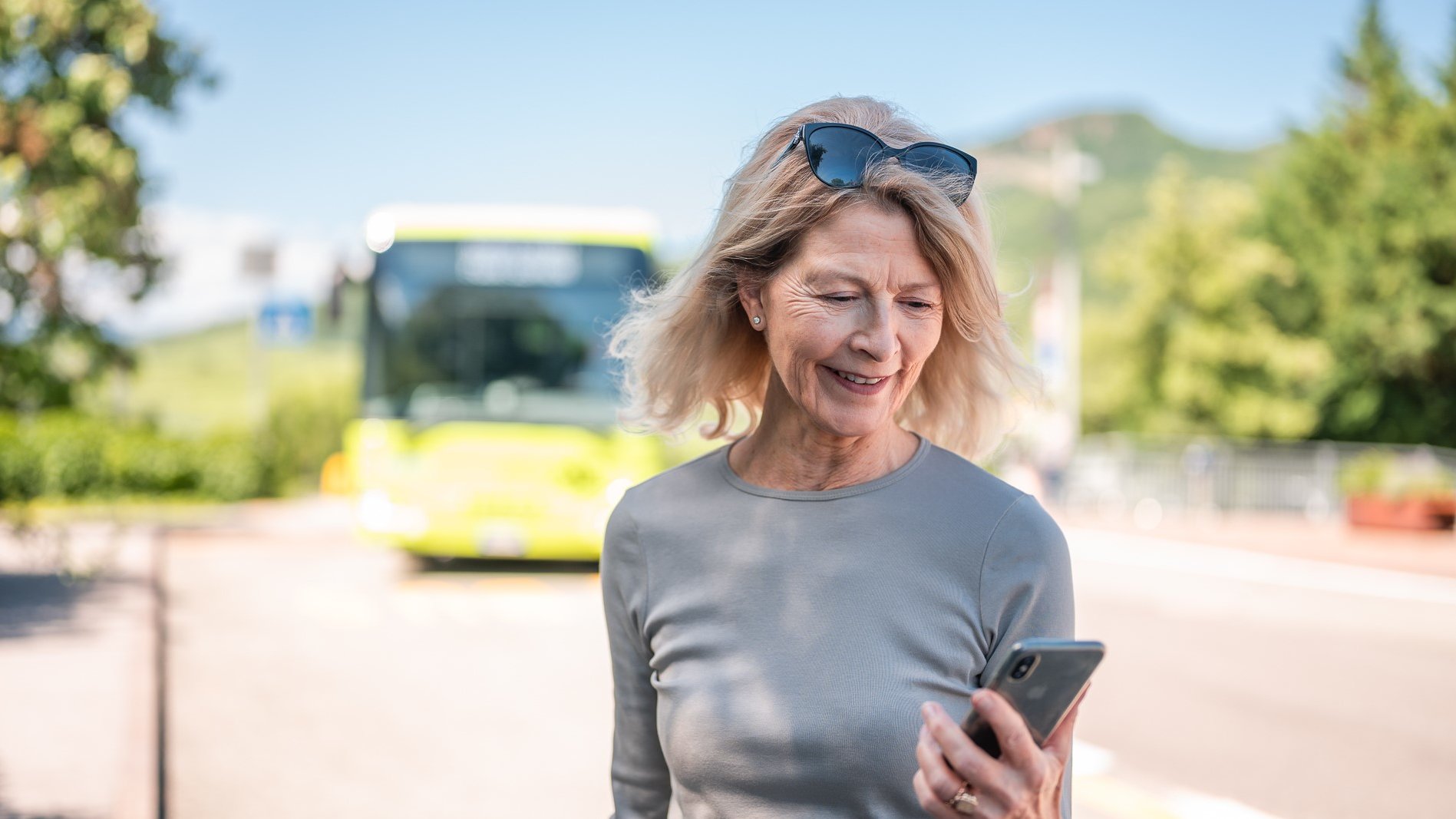 An lady uses the südtirolmobil app on her smartphone