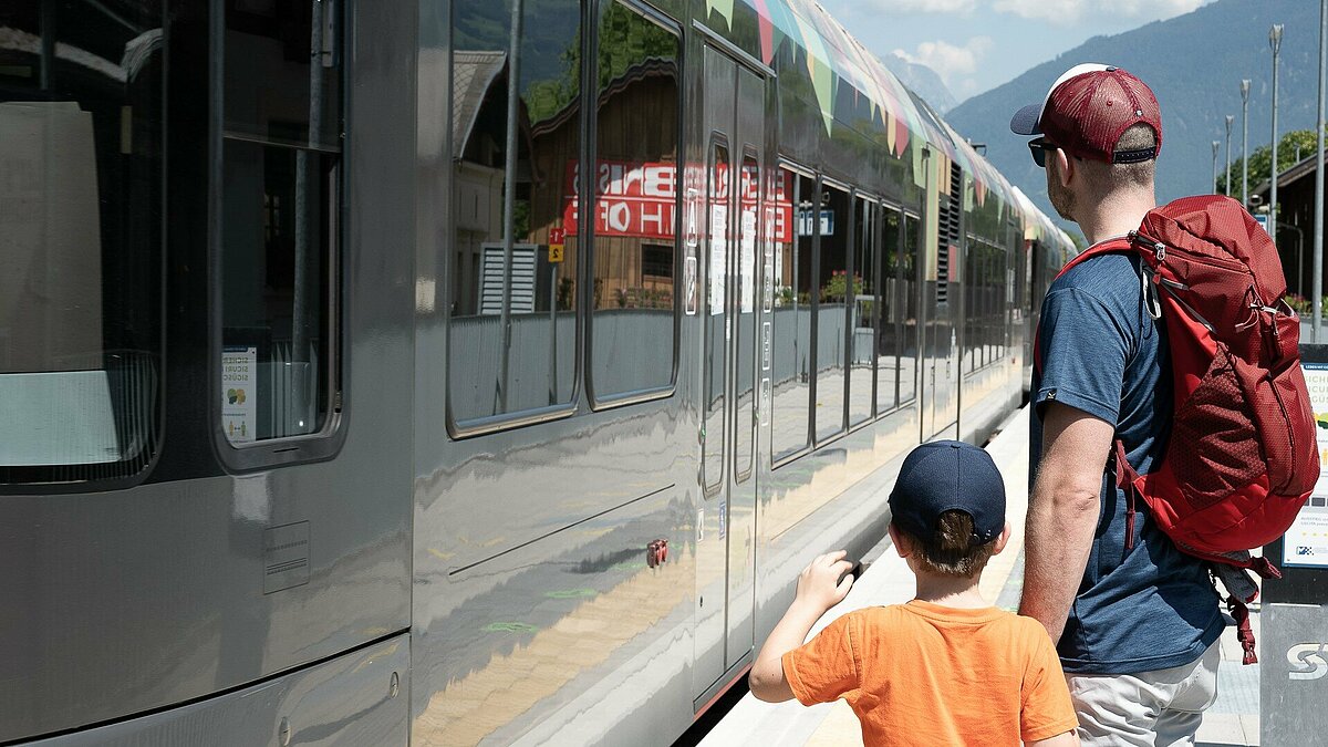 una famiglia davanti al treno della Val Venosta