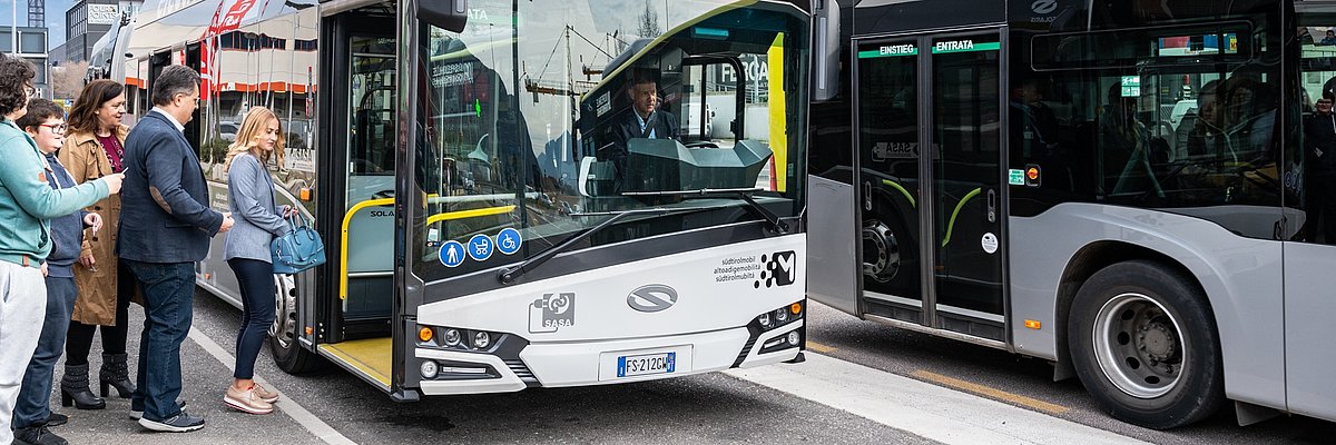 Passeggeri salgono su un bus urbano elettrico in città.