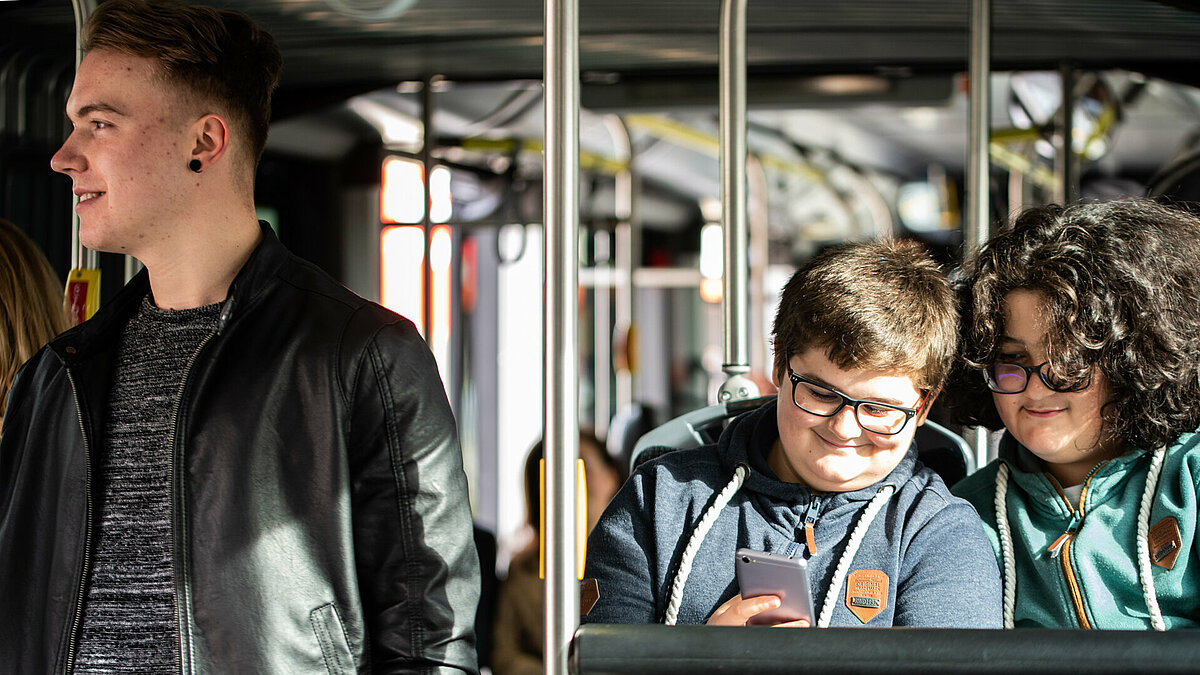 Two young people are checking the phone on the bus.