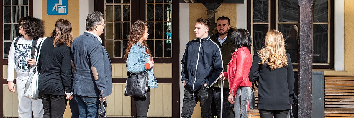 A group of people is waiting at the train station.